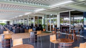 ein Restaurant mit Tischen, Stühlen und Fenstern in der Unterkunft Holiday Inn Suva, an IHG Hotel in Suva