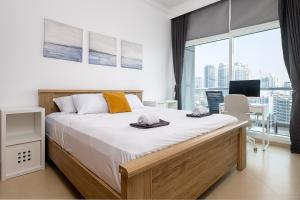 a bedroom with a large bed and a large window at Dubai Marina 2BR Beach Oasis in Dubai