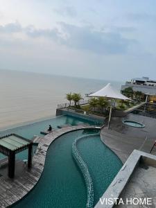 una piscina con una mesa de picnic y el océano en Imperium Residence Kuantan 2 Bedroom Sea View, en Kuantan