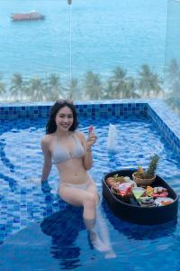 uma mulher numa piscina com uma bandeja de comida em Prime New Hotel em Nha Trang