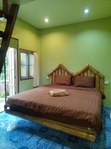 a bedroom with a large bed with a wooden headboard at Chilling Hill Guesthouse in Pai