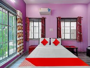 1 dormitorio con 1 cama grande con almohadas rojas en Urvashi Guest House en Durgāpur