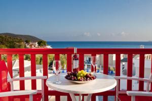 a table with a bowl of fruit and wine glasses at Viva Mare Foinikounta in Finikounta