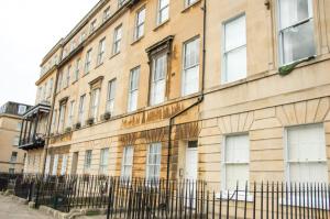 a building with a fence in front of it at Beautiful Georgian One Bedroom Apartment in Bath