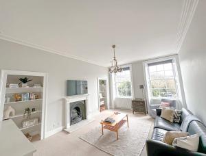 a living room with a couch and a fireplace at Beautiful Georgian One Bedroom Apartment in Bath