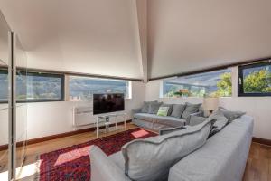 salon z kanapą i telewizorem w obiekcie Splendido attico per chi ama escursioni nella natura w mieście Grono