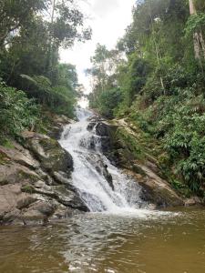 a waterfall in the middle of a river at Refúgio dos Moreiras in Monteiro Lobato