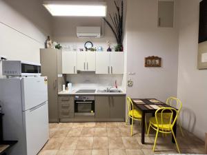 a small kitchen with a table and yellow chairs at Westside Studio Apartments in Armidale