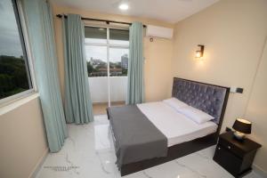 a bedroom with a bed and a large window at BNB RESIDENCE MOUNT LAVINIA 1 in Mount Lavinia