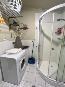 a bathroom with a washing machine and a shower at Westside Studio Apartments in Armidale