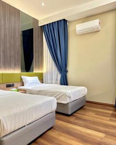 um quarto de hotel com duas camas e uma janela em I-VISTA HOTEL em Tawau