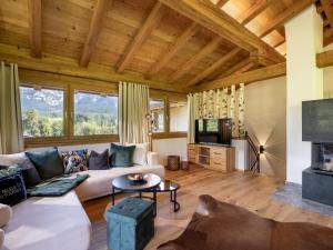 a living room with a couch and a fireplace at Das Kaiserwohl Chalet in Going