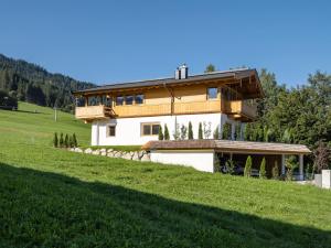a house on a hill with a green field at Das Kaiserwohl Chalet in Going
