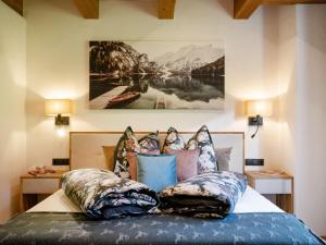 a bedroom with a bed with pillows and a painting on the wall at Das Kaiserwohl Chalet in Going