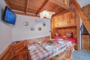 a dining room with a table and a tv at Appartamento Rochebrune 200m from Ski - Happy Rentals in Claviere