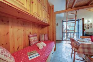 una sala de estar con un sofá rojo en una cabaña en Appartamento Rochebrune 200m from Ski - Happy Rentals en Claviere