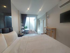 1 dormitorio con 1 cama blanca grande y TV en KVILLA en Ban Khlong Bang Chak