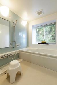Itoshima的住宿－Rakusansui Villa，带浴缸、卫生间和窗户的浴室