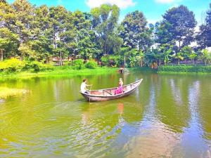 un hombre y una chica en un barco en un lago en TINA LAKESIDE AO ĐÔI Homestay Phước Hải, en Hội Mỹ