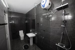 a bathroom with a shower and a toilet and a sink at BNB RESIDENCE MOUNT LAVINIA 1 in Mount Lavinia +4 photos