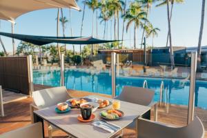 a table with food on it next to a swimming pool at Karratha International Hotel in Karratha
