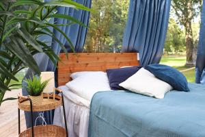 a bedroom with two beds with blue curtains and a plant at Borås Camping & Vandrahem in Borås