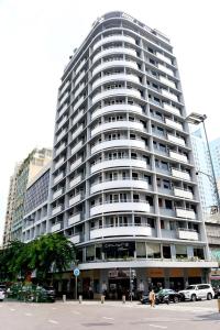 un gran edificio blanco con coches estacionados frente a él en Palace Hotel Saigon, en Ho Chi Minh