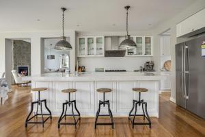 een keuken met een groot wit eiland met barkrukken bij Bellaluca Hamptons in Sorrento