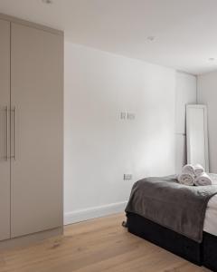 1 dormitorio con 1 cama y puerta corredera de cristal en Kensington High Street Apartments en Londres