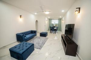 sala de estar con sofá azul y TV en BNB RESIDENCE MOUNT LAVINIA 1, en Mount Lavinia