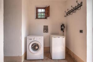 een wasruimte met een wasmachine en een wasmachine bij Casale Pian Di Menta in Manciano