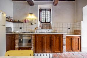 een keuken met houten kasten, een wastafel en een fornuis bij Casale Pian Di Menta in Manciano