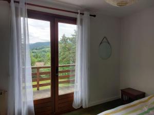 Schlafzimmer mit einem Bett und einem Fenster mit Aussicht in der Unterkunft Maison de la forêt magique. in Chalmazel Jeansagniere