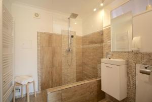 a bathroom with a shower with a glass door at Aparthotel & Seminarhaus Wolkentor in Halle an der Saale +38 photos
