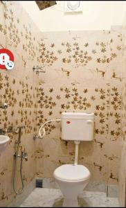 La salle de bains est pourvue de toilettes et d'étoiles dorées sur le mur. dans l'établissement Super OYO The Orchid Residency, à Kolkata