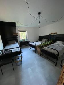 Zimmer mit 3 Betten und einem Fenster in der Unterkunft Greenspot - Loft with 2 bedrooms and free parking in Liepāja