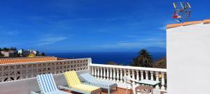 un balcón con 2 sillas, una mesa y el océano en Vv Casa Lucas, en Vallehermoso