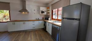 eine Küche mit einem Kühlschrank aus Edelstahl und weißen Schränken in der Unterkunft Vv Casa Lucas in Vallehermoso