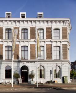 a white building with flags in front of it at Suitehotel Pincoffs in Rotterdam