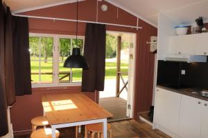 a kitchen and dining room with a table and a window at Borås Camping & Vandrahem in Borås