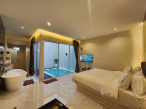 um quarto com uma banheira, uma cama e uma casa de banho em KVILLA em Ban Khlong Bang Chak