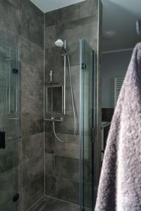 La salle de bains est pourvue d'une douche avec une porte en verre. dans l'établissement Bella Casa, à Hagen