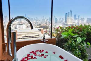 a bathroom with a bath tub with a view of the city at Grand China Bangkok in Bangkok