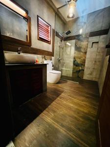 y baño con lavabo, aseo y ducha. en Adique's Resorts en Marawila