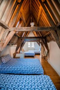 een zolder met 2 bedden in een kamer met houten plafonds bij Unieke woning in het historisch stadscentrum in Antwerpen