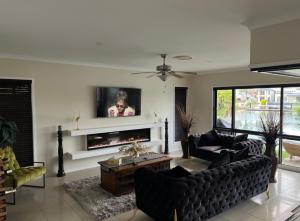 a living room with a couch and a tv at Bella Vista Bed and Breakfast of Raby Bay in Cleveland