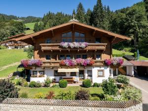 a large wooden house with flowers on the balcony at Appartement Bergblick in Brixen im Thale