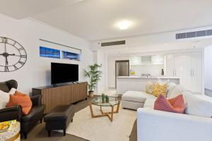 a living room with a couch and a tv at AAB Apartments Skyline in Brisbane