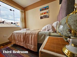 une chambre avec un lit et une grande fenêtre dans l'établissement Puma Wasi, céntrico, acogedor, bien iluminado, à Cusco