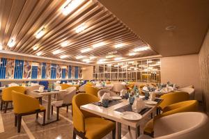 a dining room with tables and yellow chairs at Golden Tulip Bhopal in Bhopal